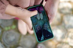 top view of a woman taking a photo of her partner's feet using a cellphone.