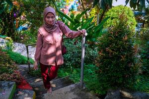 top view of a woman in a headscarf walking on the park steps facing the camera. photo