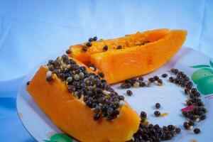cerca arriba ver de papaya Fruta aislado en plato en negro antecedentes. foto