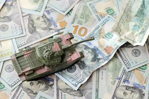Tank on crumpled hundred dollar bills banknotes. Background of war funding and military support photo