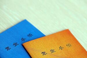 Japanese pension insurance booklets on table. Blue and orange pension book for japan photo