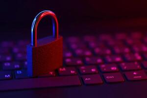 Computer security concept with a closed padlock on the keyboard. Padlock on top of a laptop keyboard. Selective focus photo