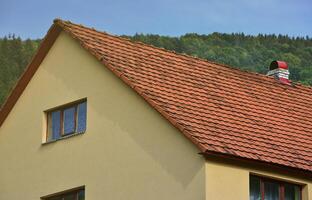 The roof of this square ceramic tile is red. The old type of roof covering in rich houses of the 19th century photo