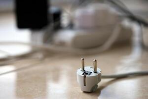 Overloaded power boards. Power strips with different electrical plugs on white floor photo