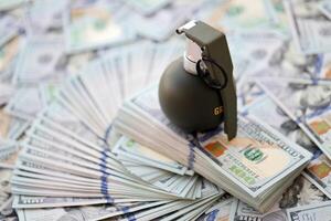 Grenade with a check against the background of huge amount of american dollar bills photo