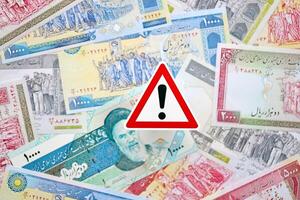 pequeño exclamación firmar mentiras en pila de iraní dinero. sanciones, prohibición o embargo concepto foto