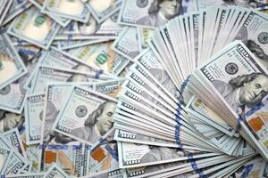 Very big amount of US hundred dollar bills. Huge quantity of united states currency notes on flat table photo