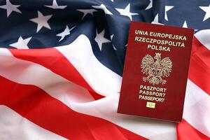 Poland passport on United States national flag background close up. Tourism and diplomacy photo