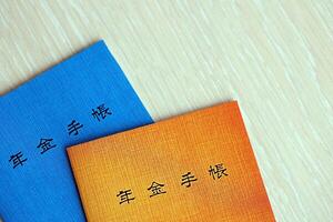 Japanese pension insurance booklets on table. Blue and orange pension book for japan photo