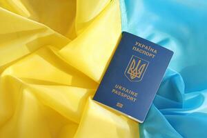 One Ukrainian biometrical passport on folded waving flag of Ukraine country photo