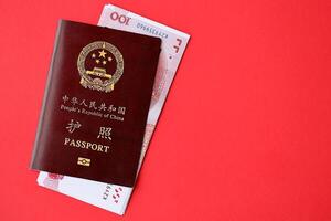 Red passport of People Republic of China and chinese yuan money bills. PRC chinese passport photo