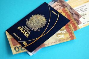 Blue Brazilian passport with money and airline tickets on blue background close up photo