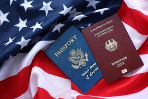 pasaporte de Alemania con nosotros pasaporte en unido estados de America doblada bandera foto