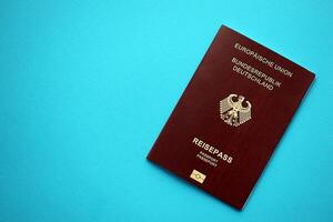 Red German passport of European Union on blue background close up photo