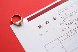 japonés matrimonio registro blanco documento y Boda proposición anillo en mesa foto