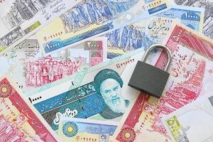 Small padlock lies on pile of iranian money. Sanctions, ban or embargo concept photo