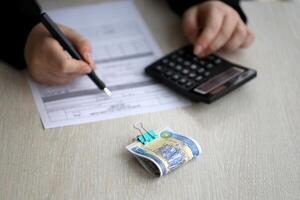 Accountant start to fill Iranian tax form on office table. Taxation period and annual taxpayers routine photo