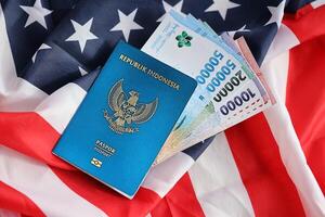 Blue Republic Indonesia passport and money on United States national flag background photo