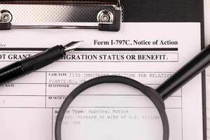 I-797c Notice of action blank form on A4 tablet lies on office table with pen and magnifying glass photo