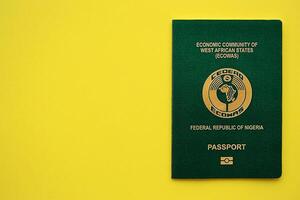 Green Nigerian passport on yellow background close up photo