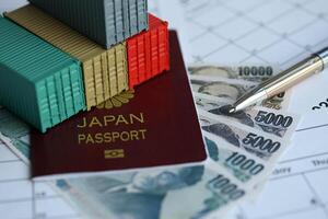 Company shipping cargo containers in Japan with yen money bills and pen photo