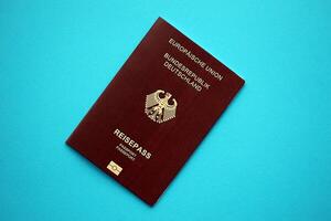 Red German passport of European Union on blue background close up photo