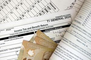 Canadian T1 General tax form Income tax and benefit return lies on table with canadian money bills photo