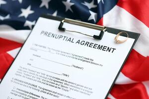 Prenuptial agreement and wedding ring on table. Premarital paperwork process in USA photo