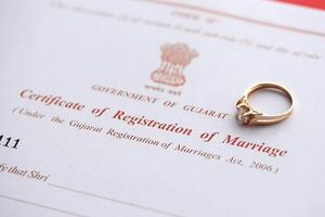 indio certificado de registro de matrimonio blanco documento y Boda anillo en mesa foto