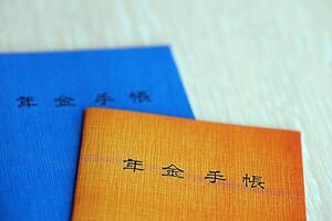 Japanese pension insurance booklets on table. Blue and orange pension book for japan photo