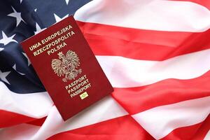 Poland passport on United States national flag background close up. Tourism and diplomacy photo