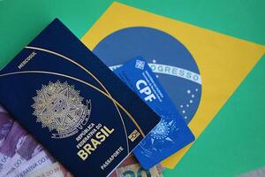 Passport book of Federative Republic of Brazil, CPF taxpayer card and brazilian reais money bills photo