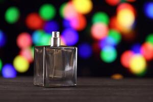 Women fragrance perfume bottle on dark festive background close up. Unnamed blank sprayer bottle of perfume photo