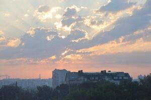 Beautiful sunrise with warm orange sunlight and beams through blue sky photo