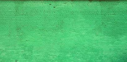 la textura de la pared de ladrillo de muchas filas de ladrillos pintados de color verde foto