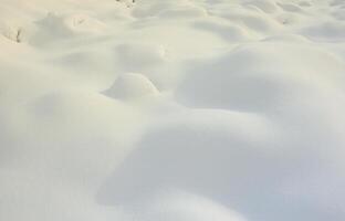 Fragment of the road, covered with a thick layer of snow. The texture of the glistening snow cover photo