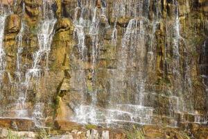 Beautiful waterfall between large rocks in autumn forest. Sofievskiy park in Uman, Ukraine photo