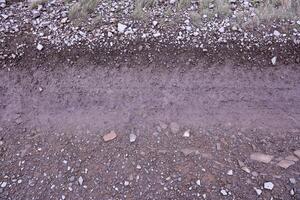 antecedentes de destrozado pedregoso piedras superficie en montaña área. textura con natural ligero foto