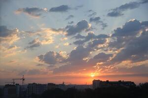 Beautiful sunrise with warm orange sunlight and beams through blue sky photo