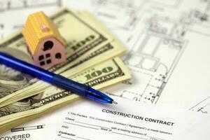 Residential construction agreement ready to sign with small toy houses and pen. Construction contract photo