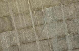The texture of a wall of large granite tiles that are covered with white streaks when exposed to dampness photo