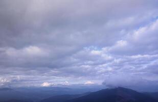 Morning view from the Dragobrat mountain peaks in Carpathian mountains, Ukraine. Cloudy and foggy landscape around Drahobrat Peaks photo