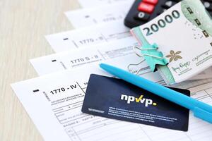 anual individual ingresos impuesto regreso formas con bolígrafo y indonesio rupia cuentas foto
