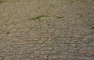 The texture is very old and inaccurately laid out pavers made of relief stones of various shapes photo