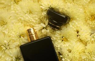 Women fragrance perfume bottle with flowers background close up. Unnamed blank sprayer bottle of perfume photo