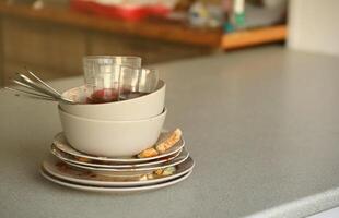 Stack of dirty dishes with food leftovers on the table after meal. Banquet ending concept. Unwashed dishes photo