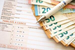 Filling italian tax form process with pen and euro money bills close up. Tax paying period photo