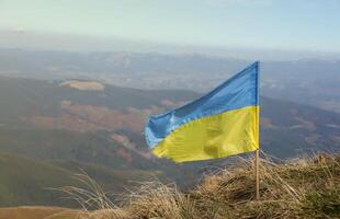 Ukrainian flag on top of Hoverla mountain in Ukraine photo