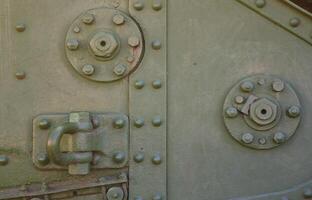 The texture of the wall of the tank, made of metal and reinforced with a multitude of bolts and rivets. Images of the covering of a combat vehicle from the Second World War photo