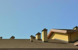 Modern roofing and decoration of chimneys. Flexible bitumen or slate shingles. The absence of corrosion and condensation due to the flexible roof photo